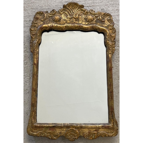 1333 - A vintage gilt framed wall hanging mirror with ornate detail to top. Approx. 63cm tall x 40cm wide.