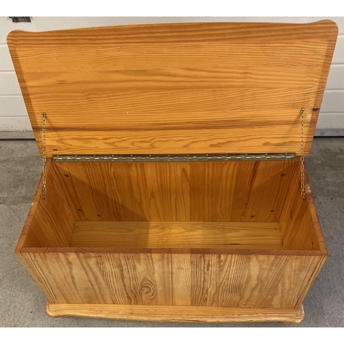 1438 - A modern pine blanket/toy chest with lift up lid and bun feet. Approx. 45cm tall x 86cm long.