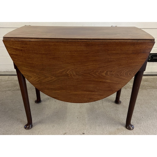 1440 - A Georgian mahogany oval topped, drop leaf dining table with pull out leg supports. Raised on straig... 