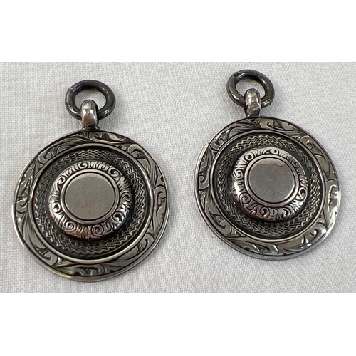 1115 - 2 vintage silver circular medallion fobs with central empty cartouche. Floral and engine turned deco... 