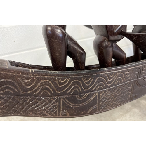 1276 - A large carved African sea dragon canoe with 12 carved African tribal figures each with a weapon. 10... 