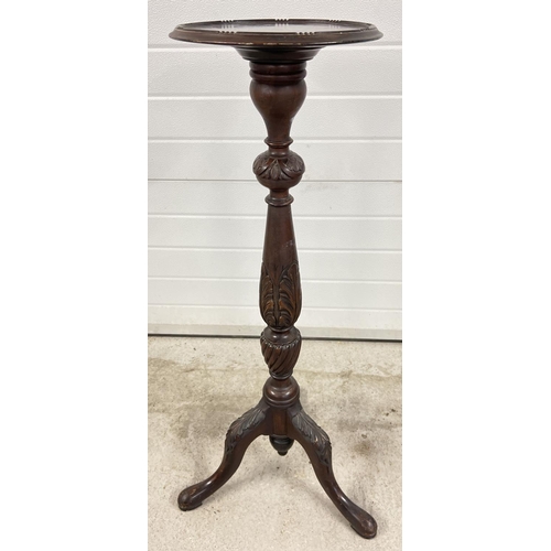 1446 - An antique mahogany torchere with carved floral detail to legs and pedestal. Bead rim detail to top.... 