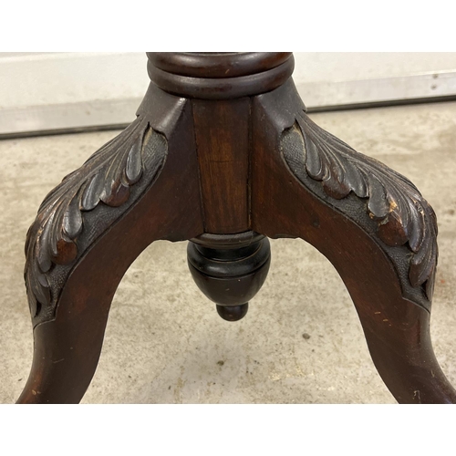 1446 - An antique mahogany torchere with carved floral detail to legs and pedestal. Bead rim detail to top.... 