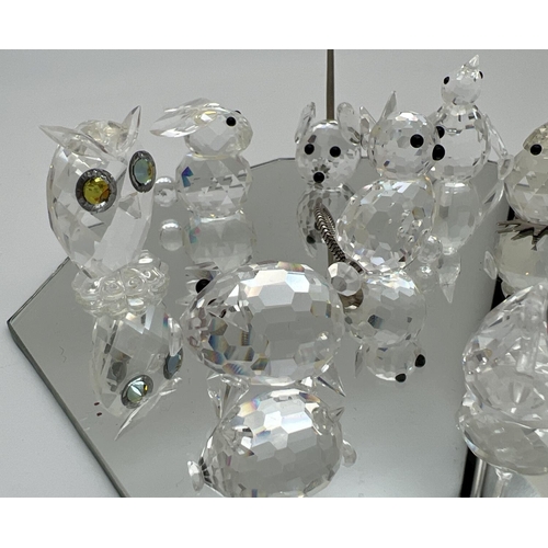 1258 - A collection of small Swarovski crystal animal figures on a mirrored stand. All etched with the squa... 