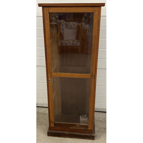 1449 - A tall dark wood glass fronted display cabinet on plinth base. Interior shelves missing. Approx. 137... 