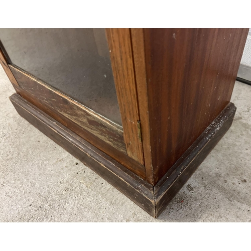 1449 - A tall dark wood glass fronted display cabinet on plinth base. Interior shelves missing. Approx. 137... 