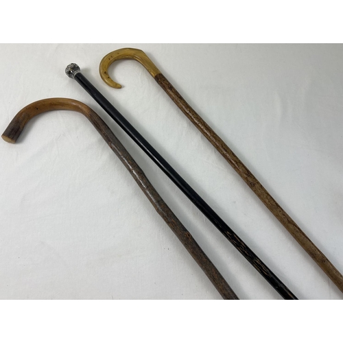 1351 - An antique silver topped walking cane together with a horn handled walking stick and a vintage woode... 