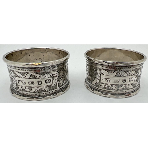 1122 - A pair of cased Victorian silver napkin rings engraved with decorative foliate design and each with ... 