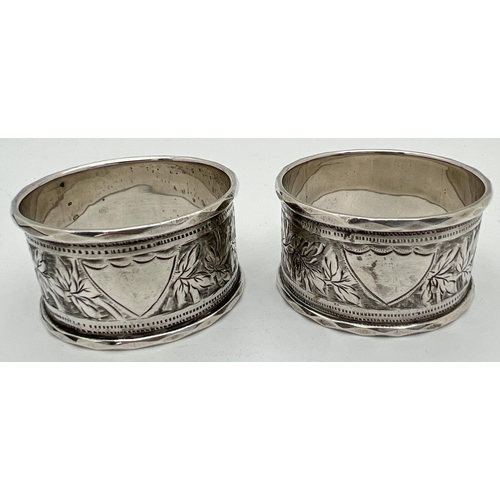 1122 - A pair of cased Victorian silver napkin rings engraved with decorative foliate design and each with ... 