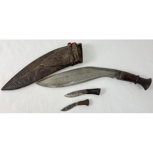 1192 - A vintage leather sheathed, curve bladed Gurkha Kukri knife, with 2 small karda knives - 1 not origi... 