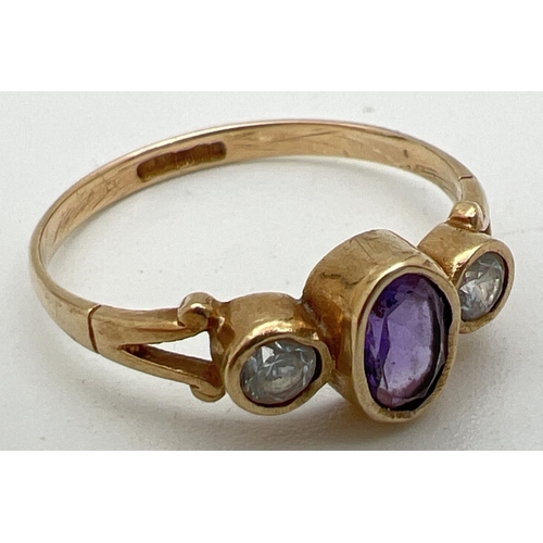 1002 - A 9ct gold, amethyst and cubic zirconia dress ring. Set with central bezel set oval amethyst flanked... 