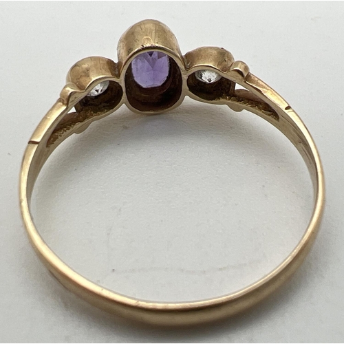 1002 - A 9ct gold, amethyst and cubic zirconia dress ring. Set with central bezel set oval amethyst flanked... 