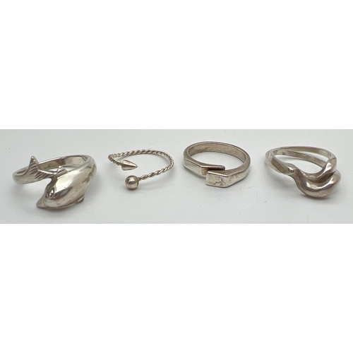 1023 - 4 silver and white metal rings. To include wrap around dolphin ring and modern contemporary design. ... 