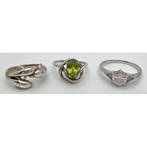 1036 - 3 modern design dress rings. A wrap around Dolphin ring, a hexagonal cut clear stone solitaire and a... 