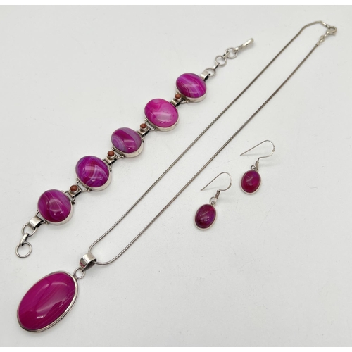 1038 - A matching set of silver and pink dyed agate jewellery. A pair of oval drop earrings, an oval panel ... 