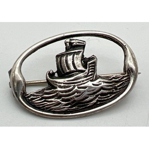 1039 - A vintage silver oval shaped brooch modelled as a Viking ship on the sea. Hallmarked Robert Allison,... 