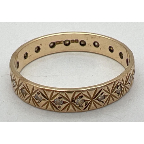 1072 - A vintage 9ct patterned gold and clear stone eternity ring. Hallmarks to inside of band. Ring size Q... 