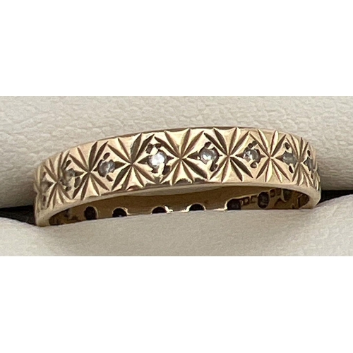 1072 - A vintage 9ct patterned gold and clear stone eternity ring. Hallmarks to inside of band. Ring size Q... 