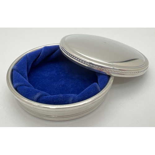 1150 - A round pewter lidded trinket box by Tiffany & Co.  with beaded decoration to edge of lid. Blue velv... 