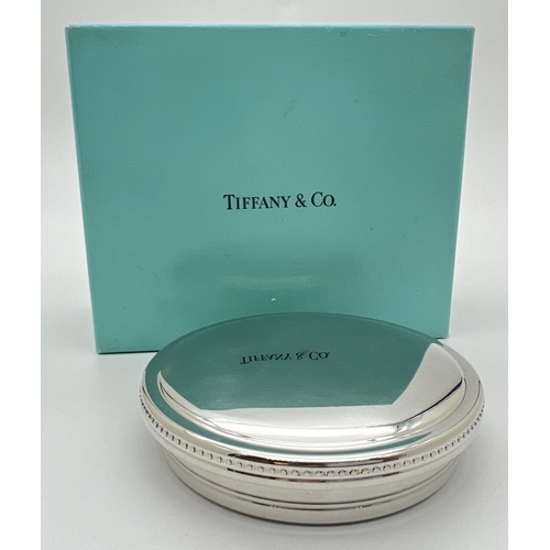 1150 - A round pewter lidded trinket box by Tiffany & Co.  with beaded decoration to edge of lid. Blue velv... 