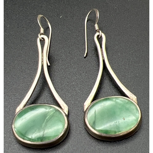 1084 - A pair of modern design silver drop earrings set with natural green stones. Silver marks to back of ... 