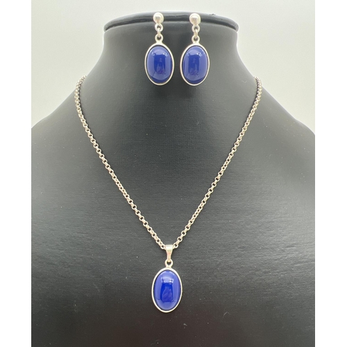 1089 - A silver pendant necklace and matching drop earrings set with oval cut blue stones. Pendant approx. ... 