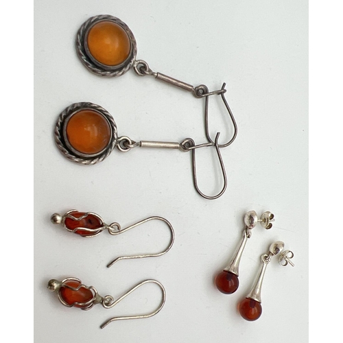 1093 - 3 pairs of modern silver and amber drop style earrings in various designs. All have silver marks to ... 