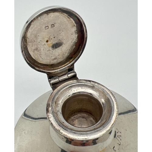 1153 - An Art Deco silver inkwell with filled base and inscription to front 