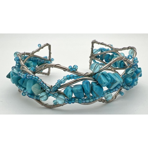 1107 - A white metal twisted design cuff bangle set with turquoise chips & small blue glass beads.