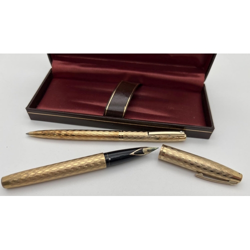 1181 - A boxed Sheaffer gold plated fountain pen and matching ball point pen with engraved engine turned de... 