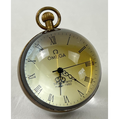 1255 - A top winding glass ball watch, bound in brass with roman numeral markers. Approx. 6cm diameter. In ... 