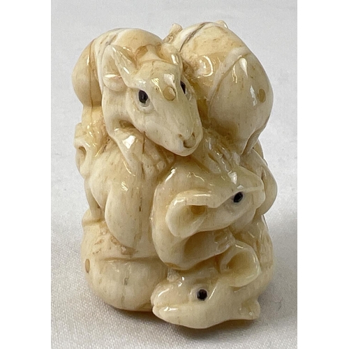 1312 - A small carved netsuke modelled as a stack of mice with polished finish and signature to underside. ... 