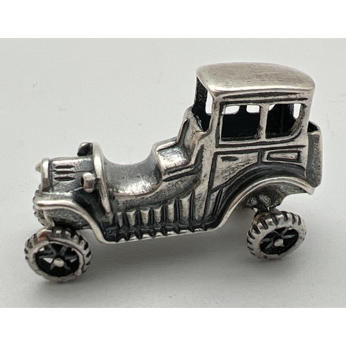 1161 - A small 925 silver model of a vintage veteran car with moving wheels. Stamped 925 to underside. Appr... 