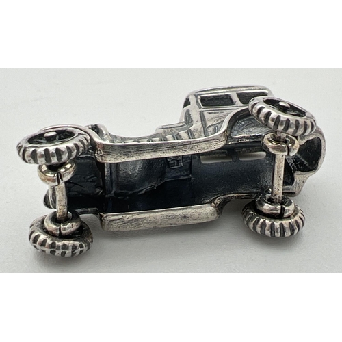 1161 - A small 925 silver model of a vintage veteran car with moving wheels. Stamped 925 to underside. Appr... 