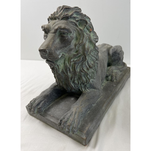 1271 - A large stoneware figure of a seated lion on a rectangular tile base, with a bronzed effect painted ... 