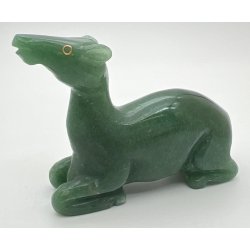 1427 - A carved jade figure of a deer, with ruby set eye (one missing). Approx. 6cm tall x 8cm long.