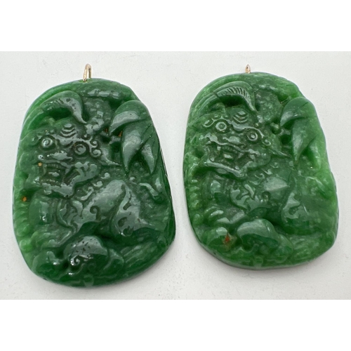 1313 - 2 jade pendants with Foo dog carved detail and gold coloured metal hanging bales. Each approx. 6cm x... 