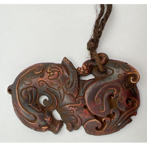 1316 - An oriental carved horn pendant modelled as a dragon. Approx. 9cm long.