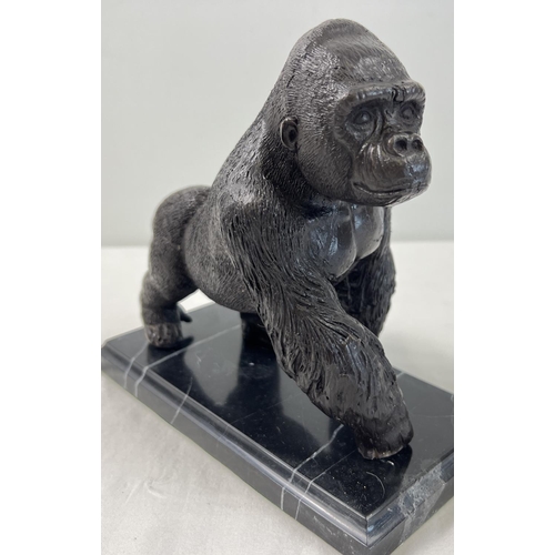 1199 - A bronze figure of a gorilla mounted on a black marble rectangular shaped base. Approx. 17cm tall x ... 