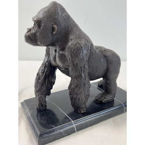 1199 - A bronze figure of a gorilla mounted on a black marble rectangular shaped base. Approx. 17cm tall x ... 