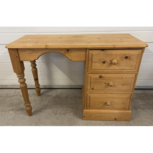 1500 - A modern pine 3 drawer dressing table with turned legs and bun drawer handles. Approx. 66 x 106 x 41... 