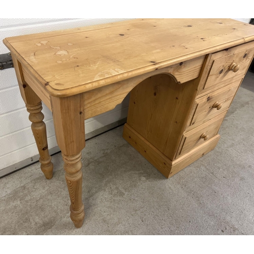 1500 - A modern pine 3 drawer dressing table with turned legs and bun drawer handles. Approx. 66 x 106 x 41... 