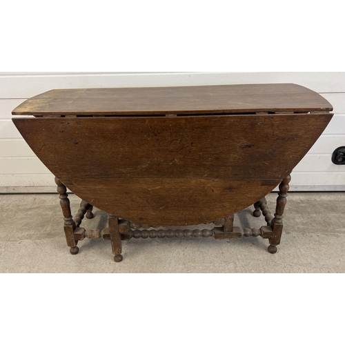 1510 - A vintage dark oak drop leaf, gate leg table with turned and bobbin design to legs and stretchers. F... 