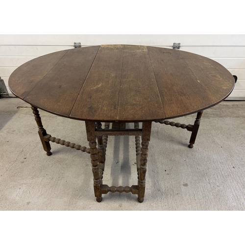 1510 - A vintage dark oak drop leaf, gate leg table with turned and bobbin design to legs and stretchers. F... 