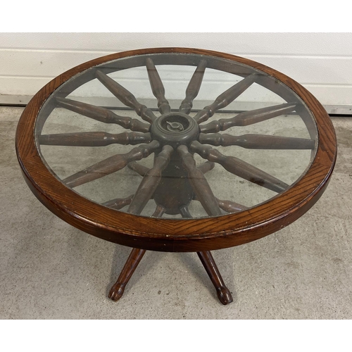 1511 - A vintage dark wood and glass topped coffee table made from a spoked wheel. Approx. 42cm tall x 75cm... 