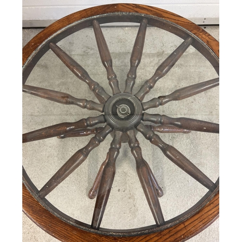 1511 - A vintage dark wood and glass topped coffee table made from a spoked wheel. Approx. 42cm tall x 75cm... 