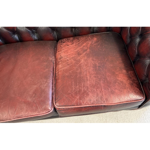 1512 - A 2 seater oxblood leather Chesterfield sofa with button back and stud detail, with matching armchai... 