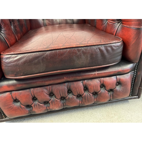 1512 - A 2 seater oxblood leather Chesterfield sofa with button back and stud detail, with matching armchai... 