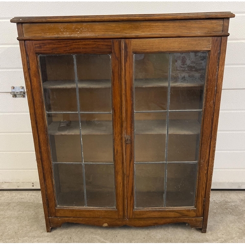 1513 - A small dark wood 2 door display cupboard with leaded glass doors. 2 interior adjustable shelves. Co... 