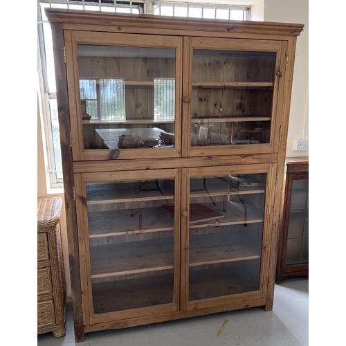 1515 - An antique pine 4 drawer linen cupboard with glazed doors and wooden knob handles. Bottom section ha... 